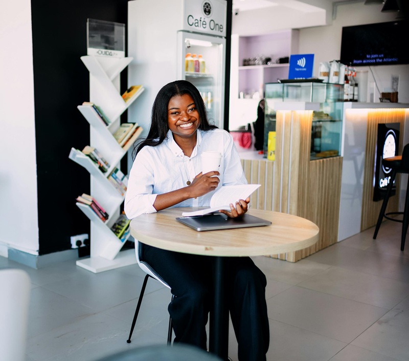 Axe team member seated with documents and a laptop in a lounge area
